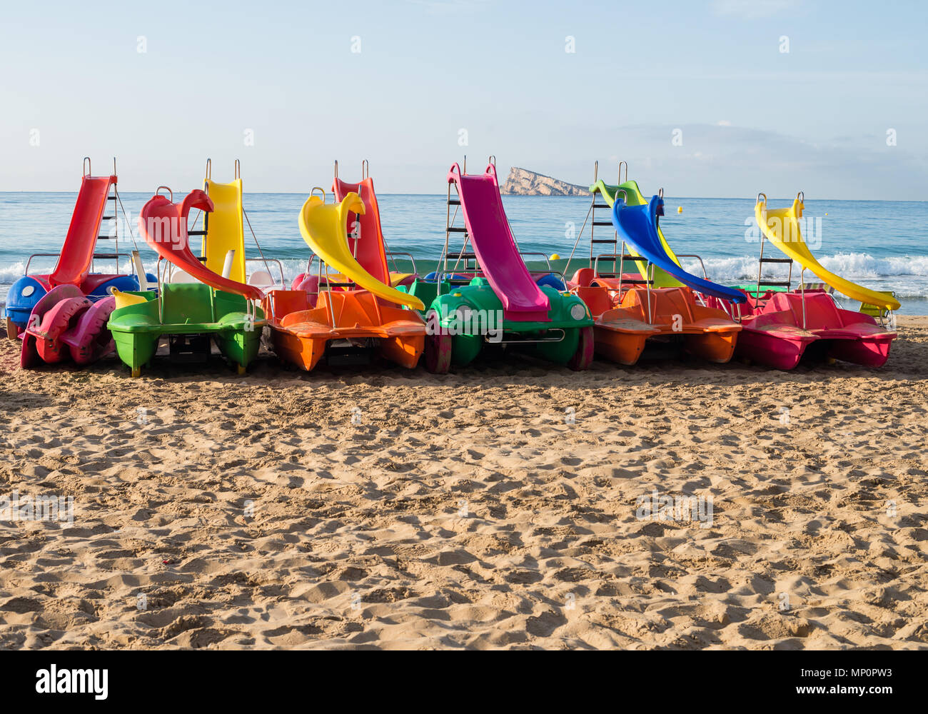 Pedakl boats on Benidorm resort beach with its landmark island in the background, Costa Blanca, Spain Stock Photo