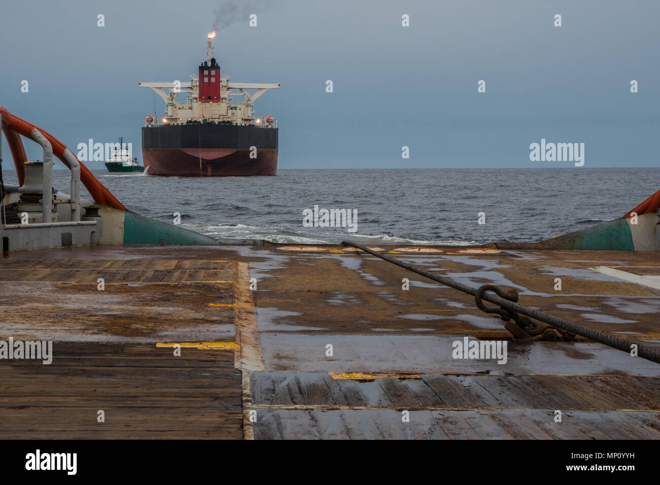 AHTS vessel doing static tow tanker lifting. Ocean tug job Stock Photo