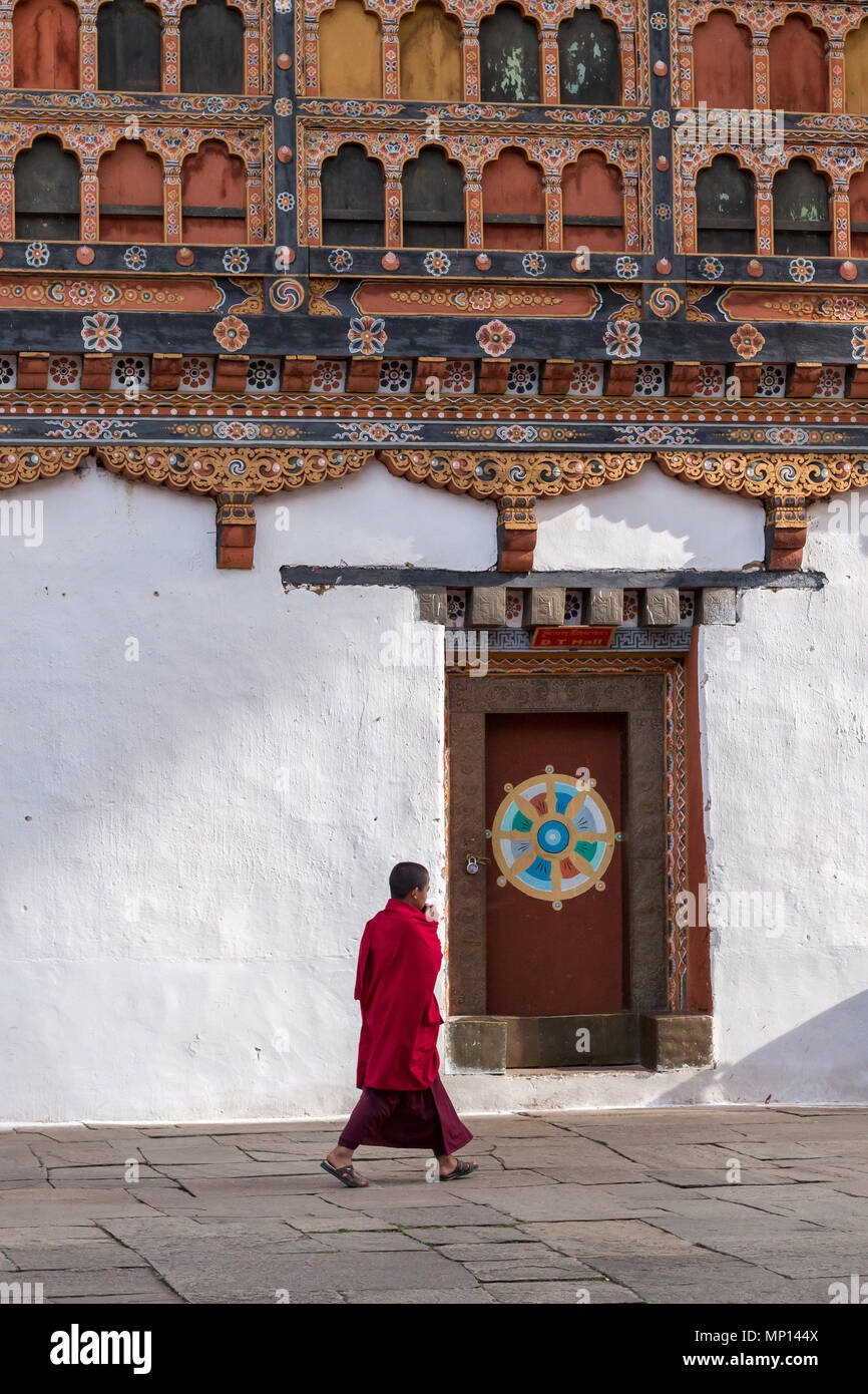 A Buddhist monk wearing purple robes walking in Rinpung Dzong (fort), Paro, Bhutan Stock Photo