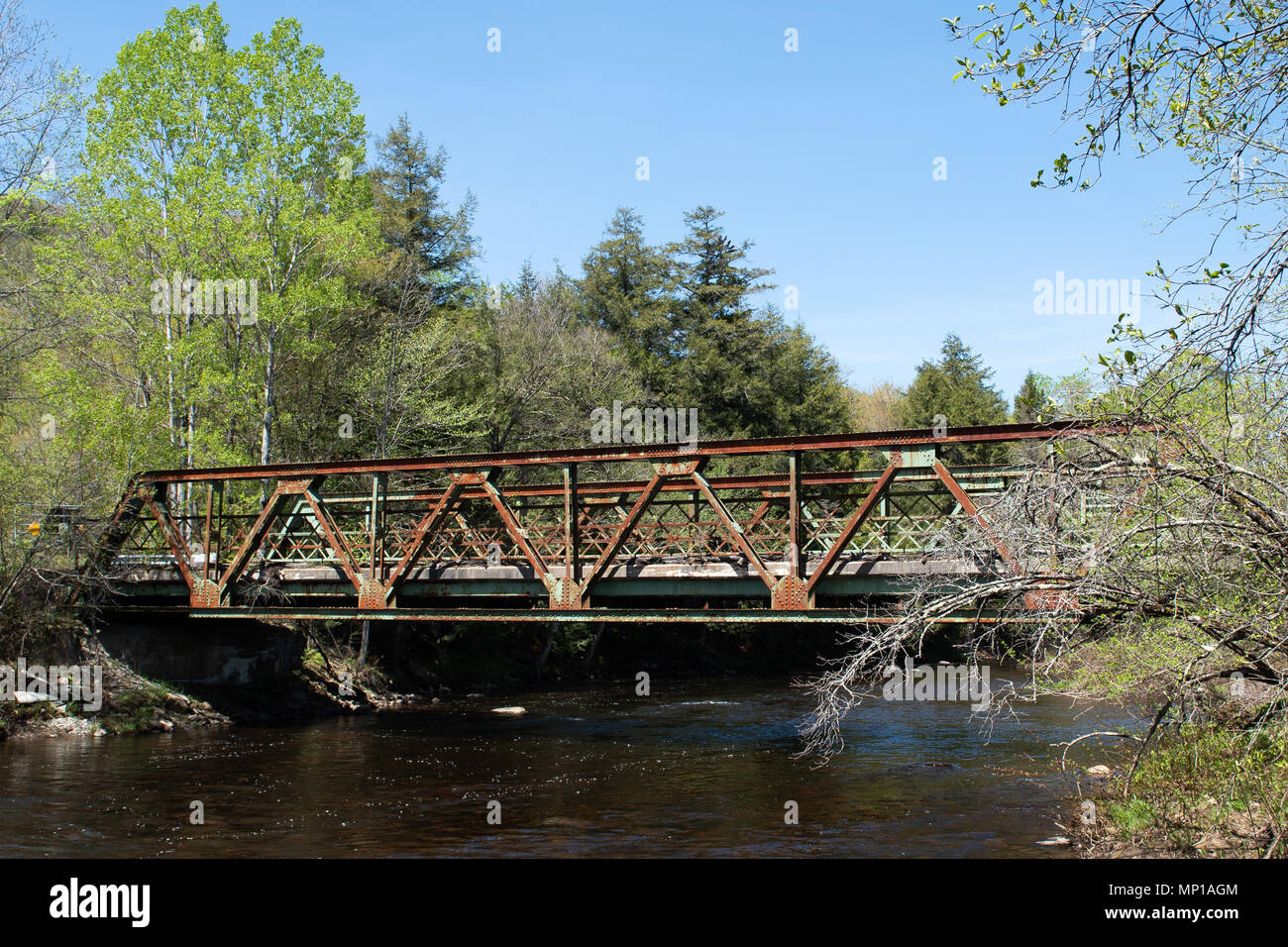 An old deteriorating closed bridge across the Sacandaga River in the Adirondack Mountains, NY, USA. Stock Photo