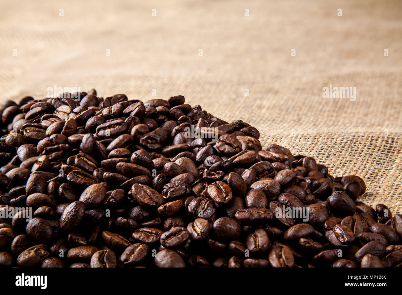 Pile of roasted coffee beans on a hessain cloth Stock Photo - Alamy