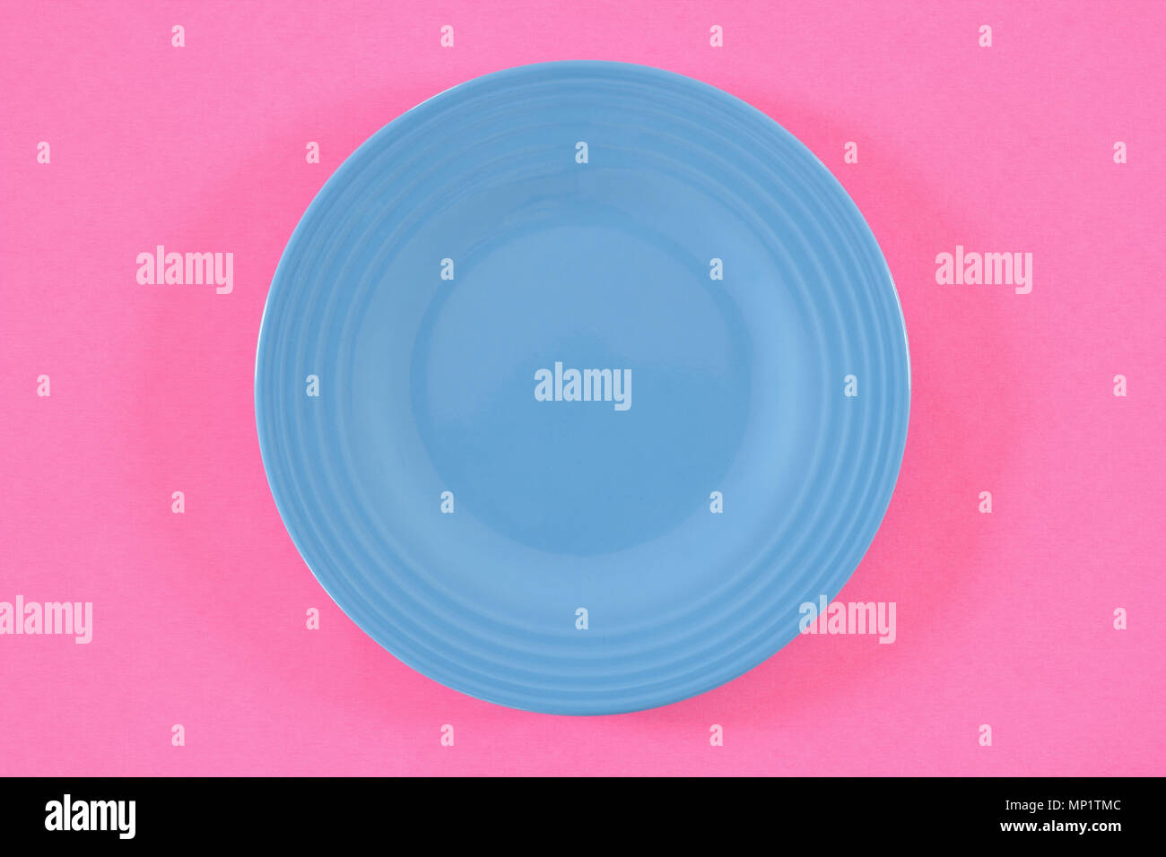 Empty blue plate on pink. From above view Stock Photo - Alamy