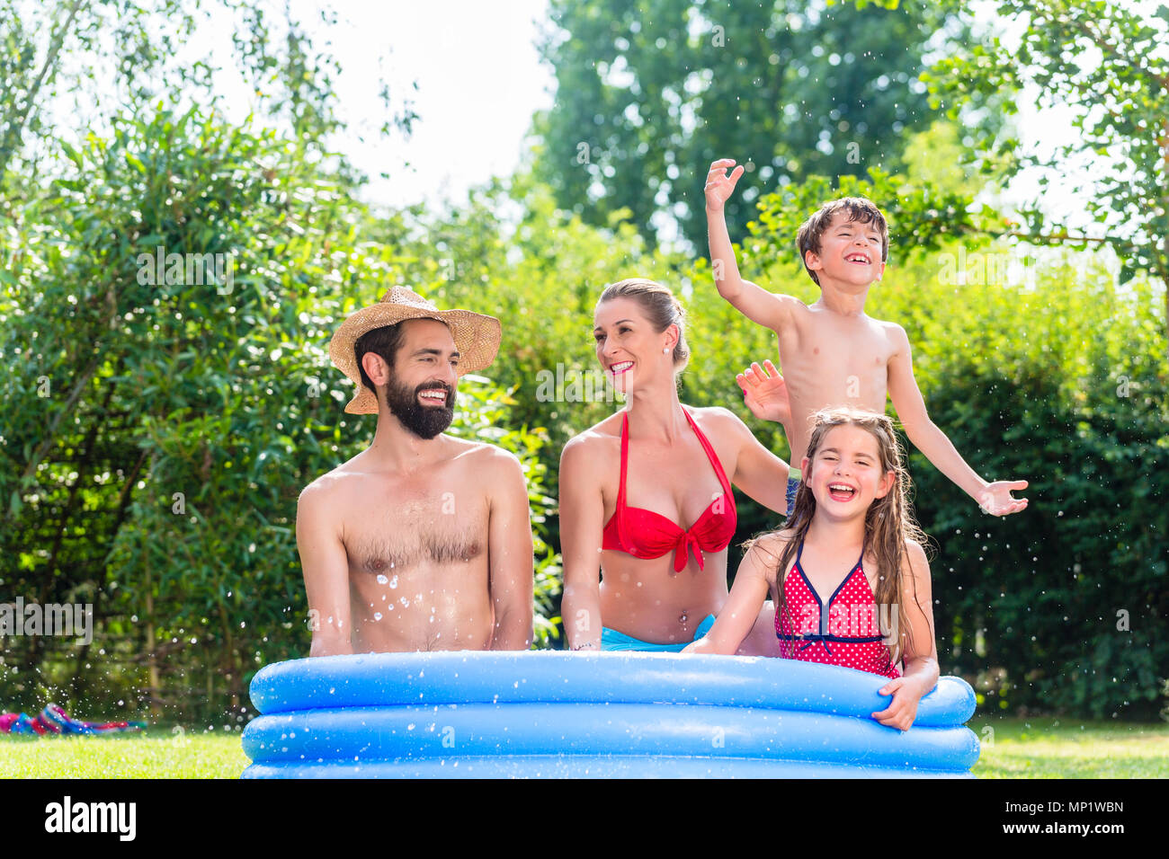 Family cooling down splashing water in garden pool Stock Photo Alamy