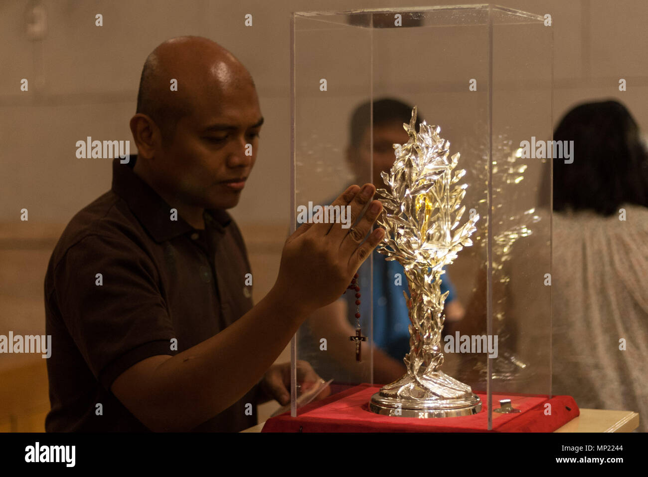 Philippines. 20th May, 2018. Devotees pray as they touch the glass encasement of the blood reliquary. The Manila Cathedral in Intramuros displayed the blood relic of Pope John Paul II for public veneration. The blood was extracted from Pope John Paul II during his battle from Parkinson's disease, in case the Pope needed an emergency transfusion. Credit: J Gerard Seguia/ZUMA Wire/Alamy Live News Stock Photo