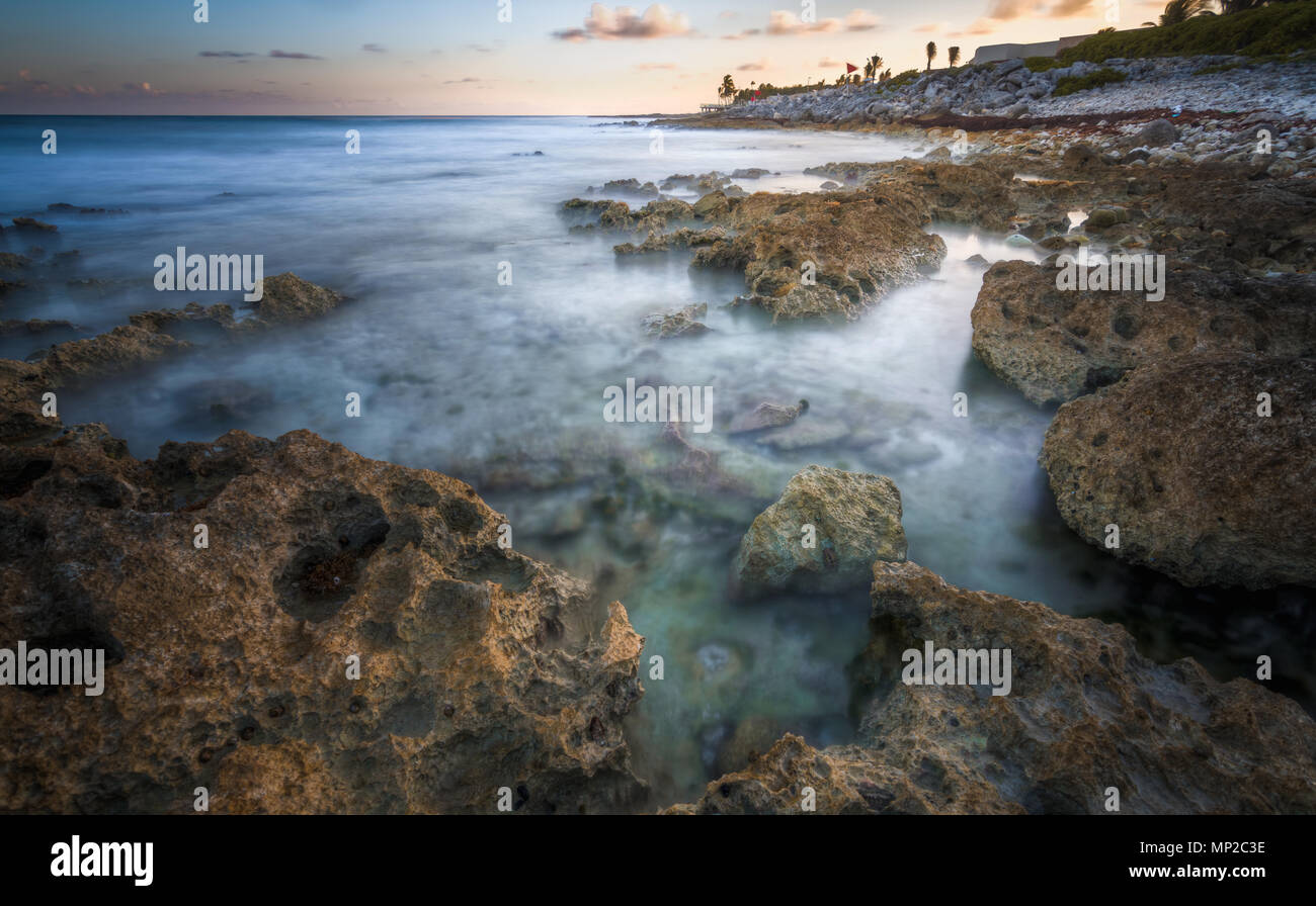 Beautiful rocky beach at dusk and sea waves Stock Photo
