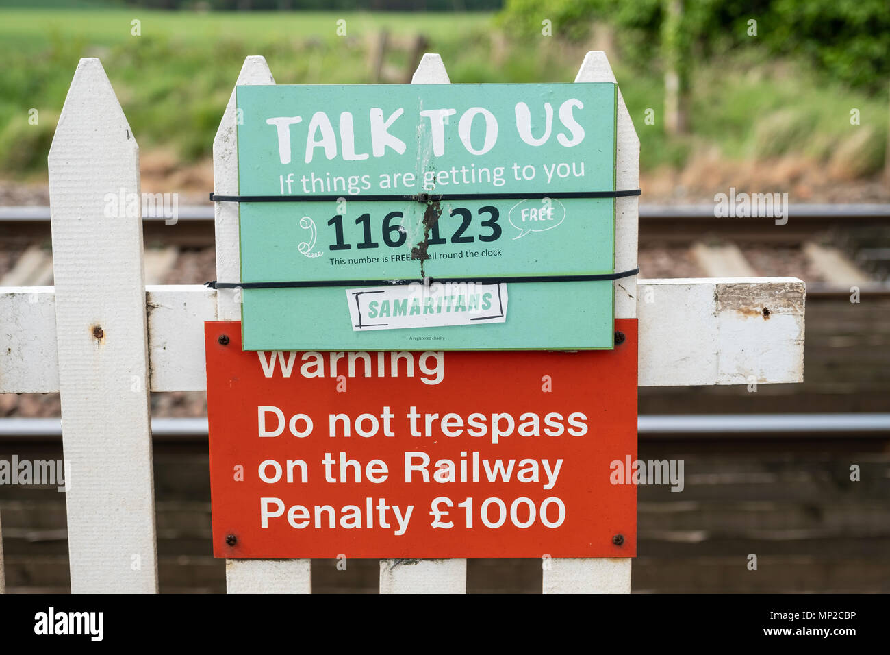 Sign of The Samaritans attached to railway level crossing in the UK. Stock Photo