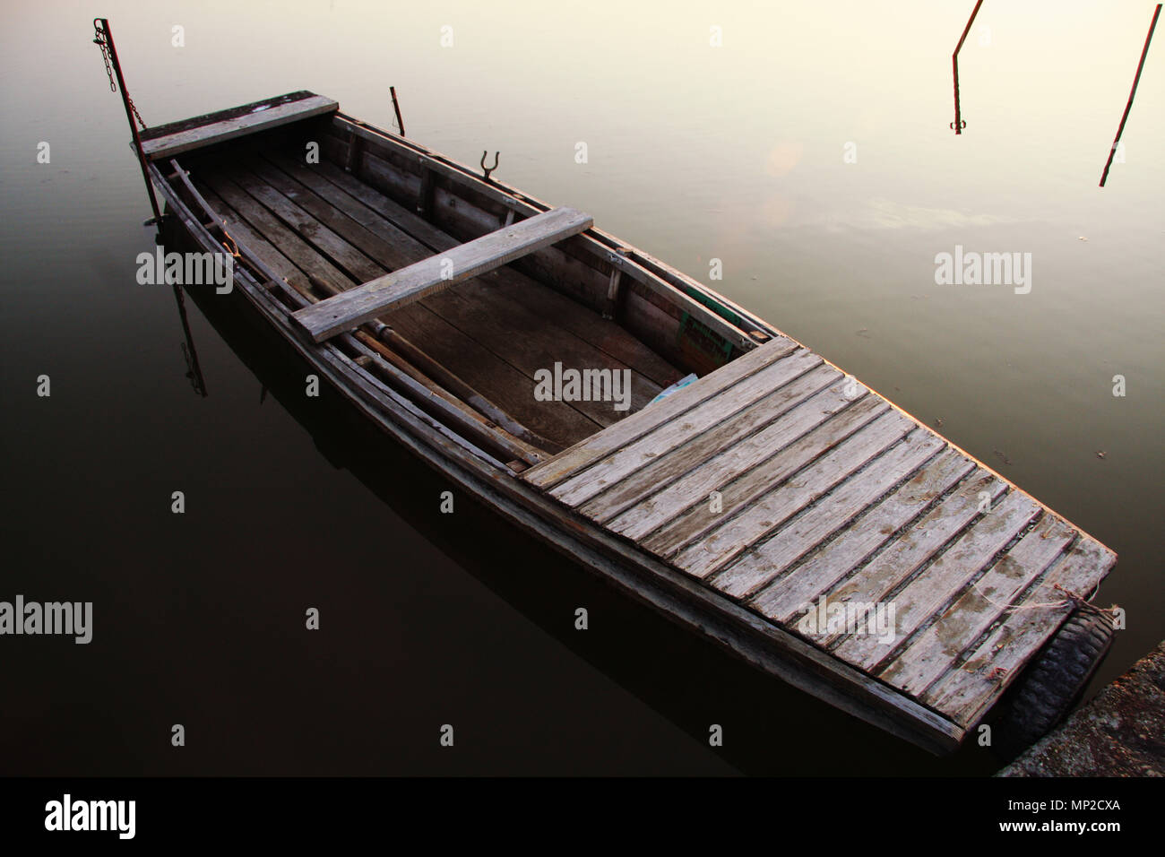 A close look of a very old wood fishing boat floating on the water in a ...