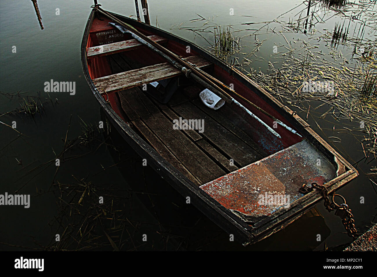 A close look of a very old wood fishing boat floating on the water in a ...