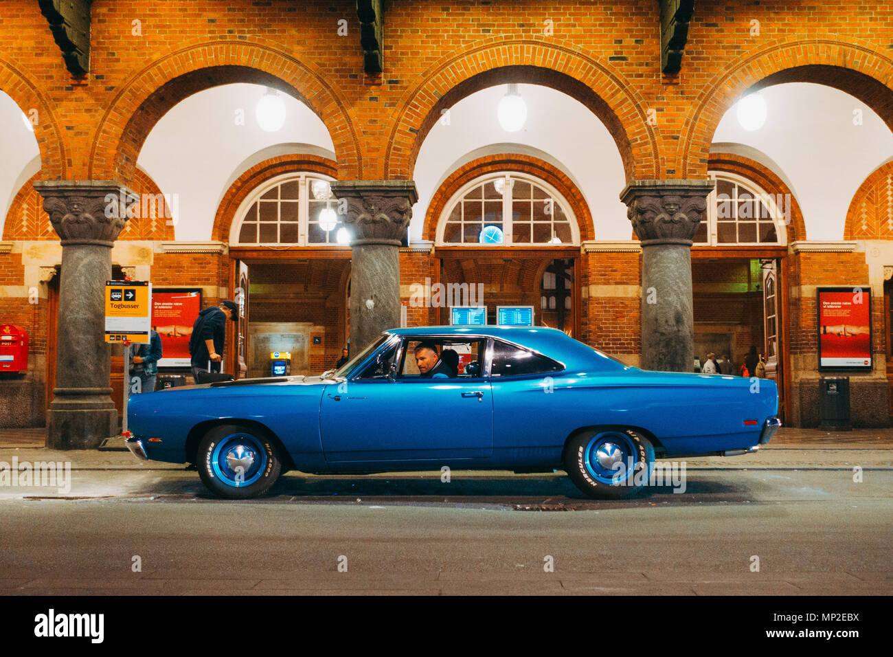 a classic 1969 Plymouth Road Runner muscle car waits outside Copenhagen Central Station, Denmark Stock Photo