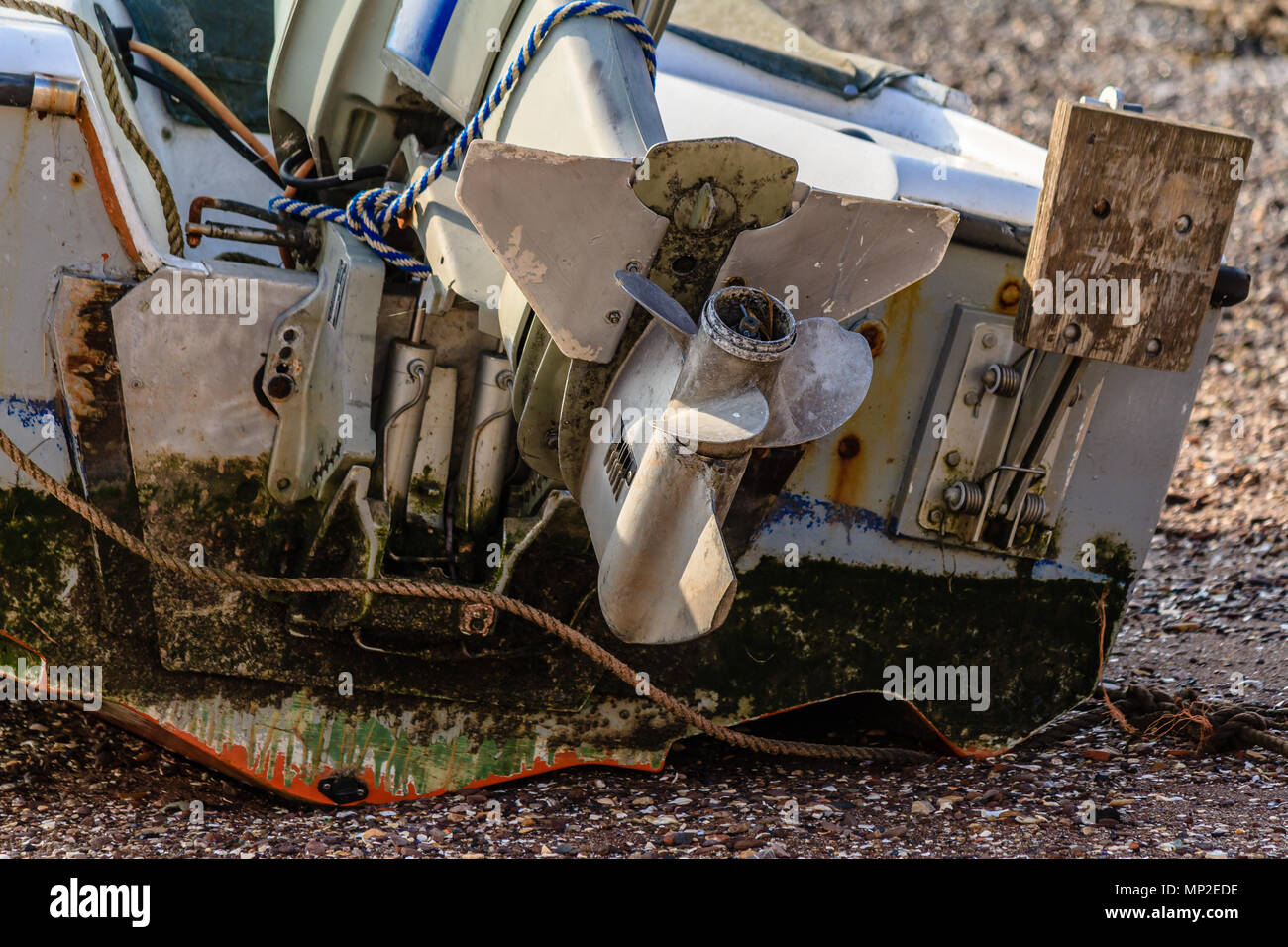 Outboard motor, attached to a boat hauled up on a beach, with the motor
