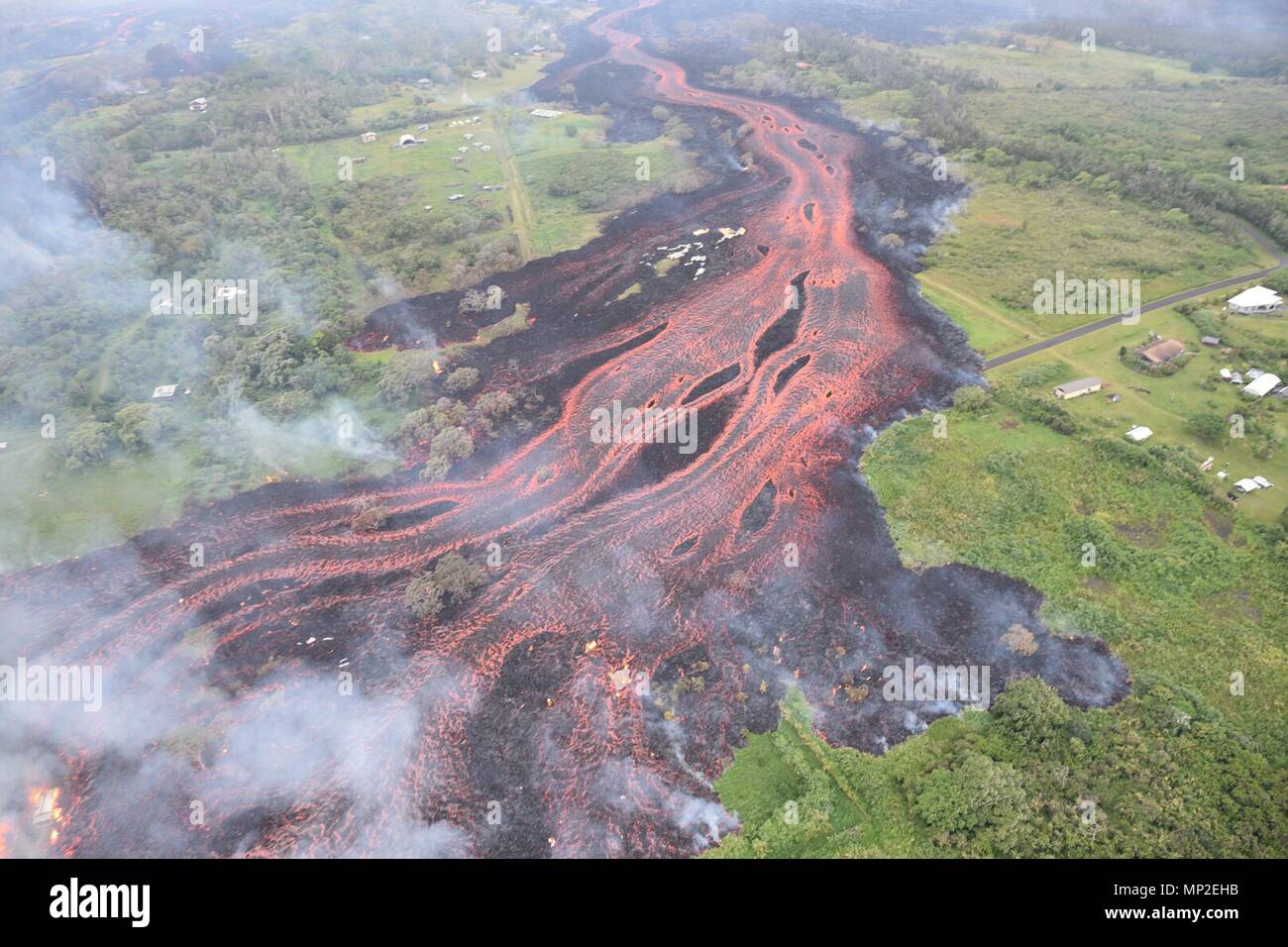 Channelized lava emerges from the elongated fissure 16-20 from the eruption of the Kilauea volcano May 19, 2018 in Pahoa, Hawaii. Stock Photo