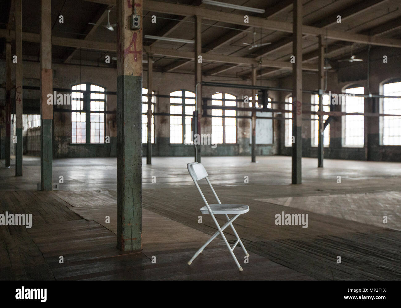 A chair in an empty factory in Patterson, NJ Stock Photo