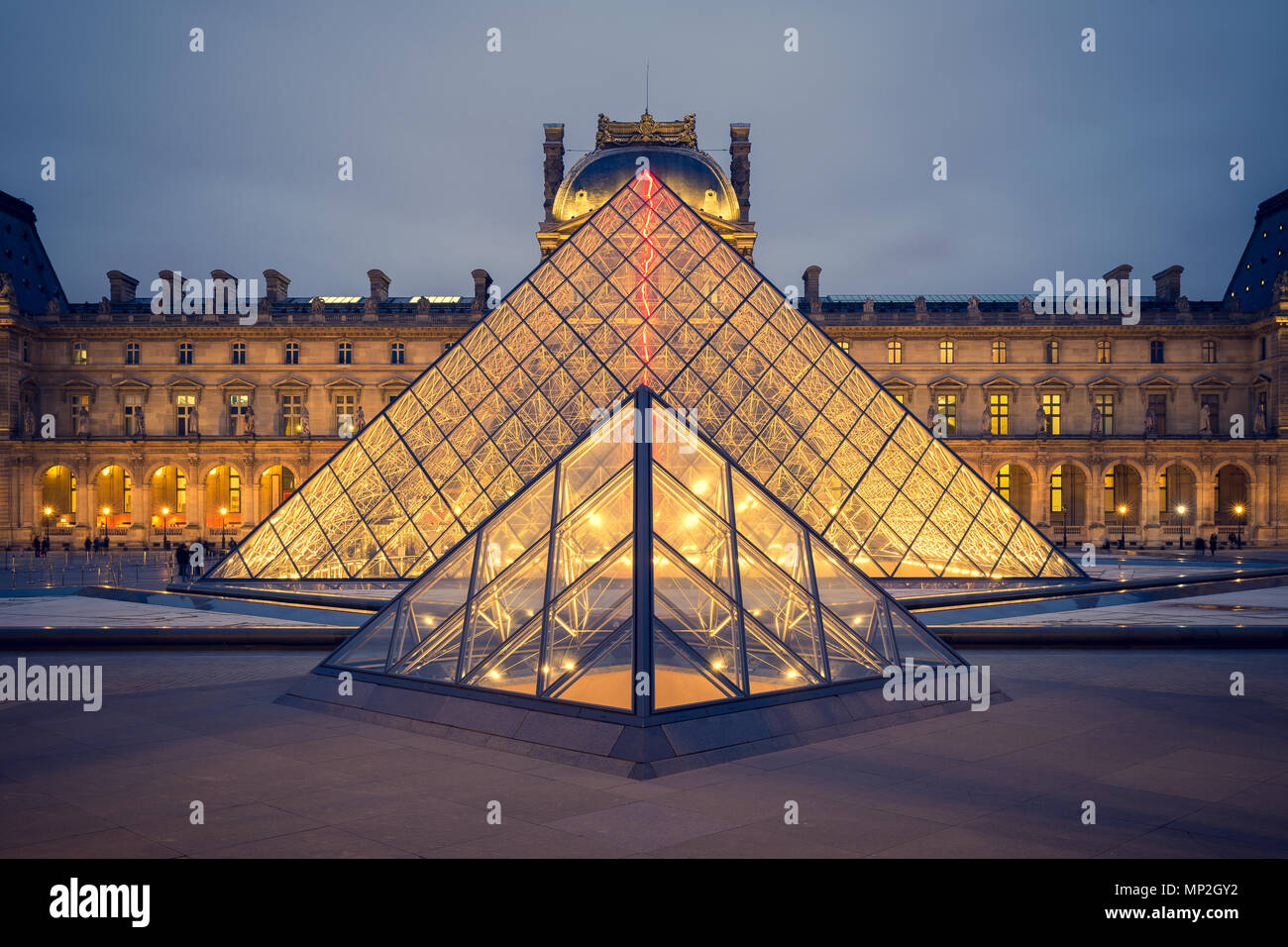 PARIS, FRANCE - FEBRUARY 22, 2016: View of famous Louvre Museum with Louvre Pyramid at evening . Stock Photo