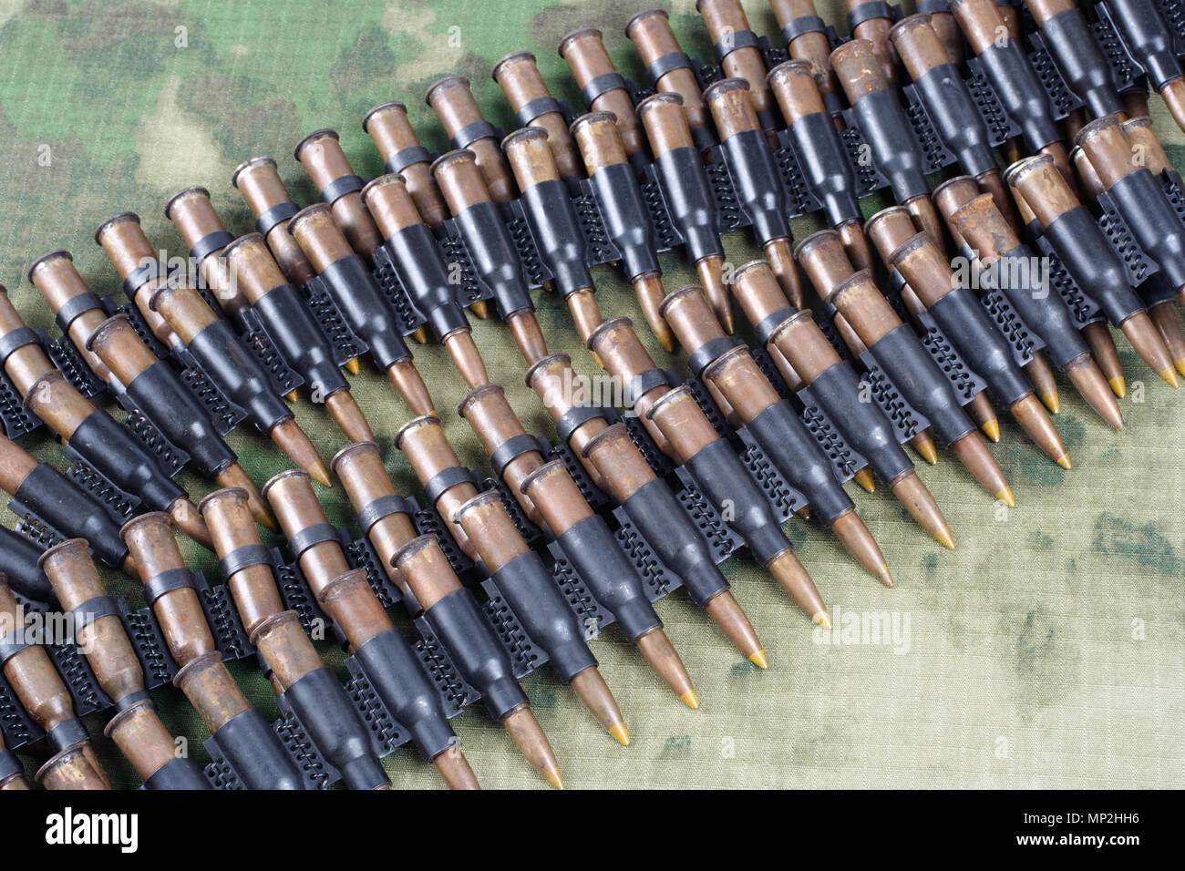 machine gun ammunition belt on camouflaged uniform background Stock