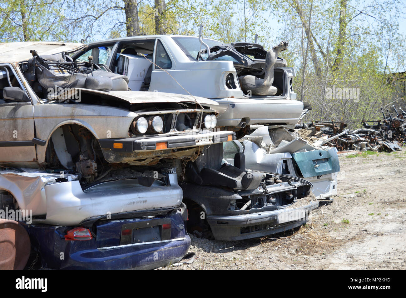 Pile of broken cars sitting on top of each other in a scrap yard Stock Photo