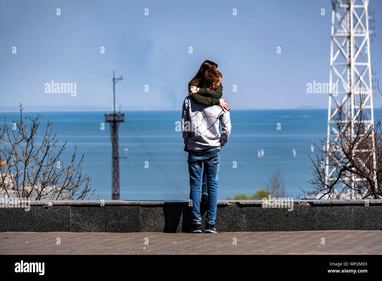 Romantic picture of young man and woman hugging each other with sea ...