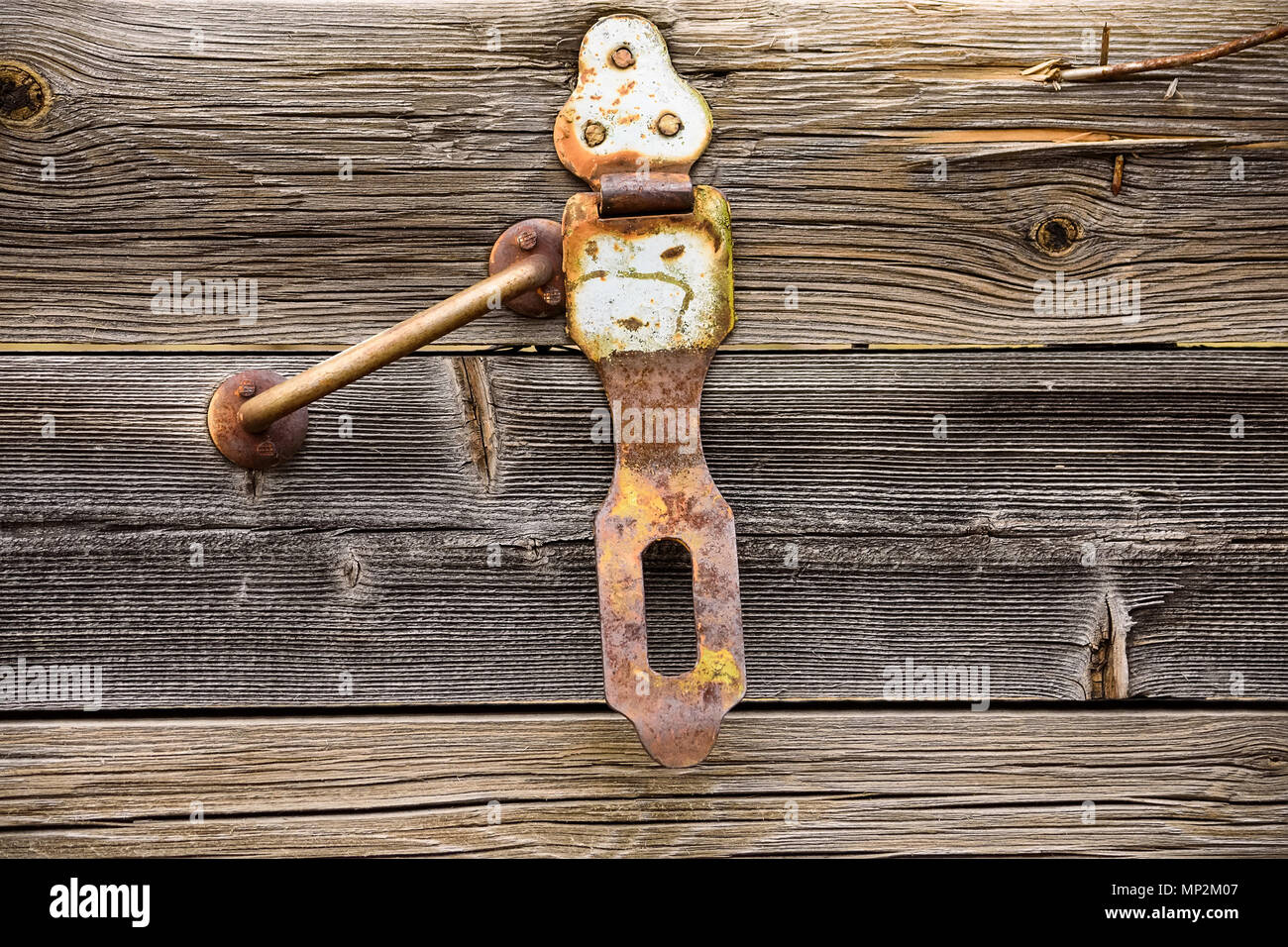 Close up old rusty handle and hinge on grey wooden texture Stock Photo