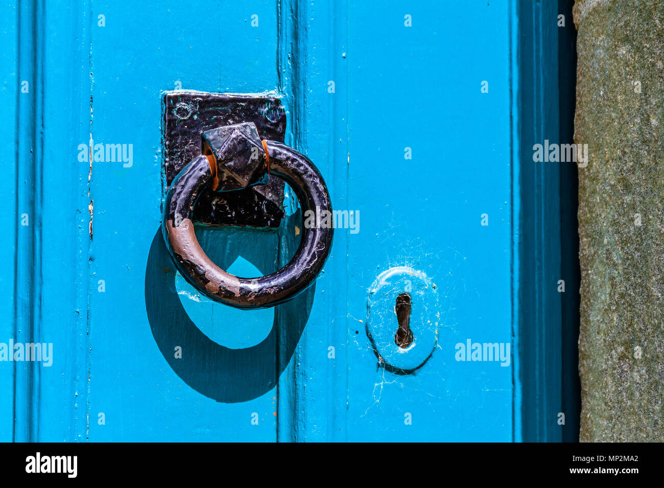 Black door handle and lock on a blue painted wooden door Stock Photo