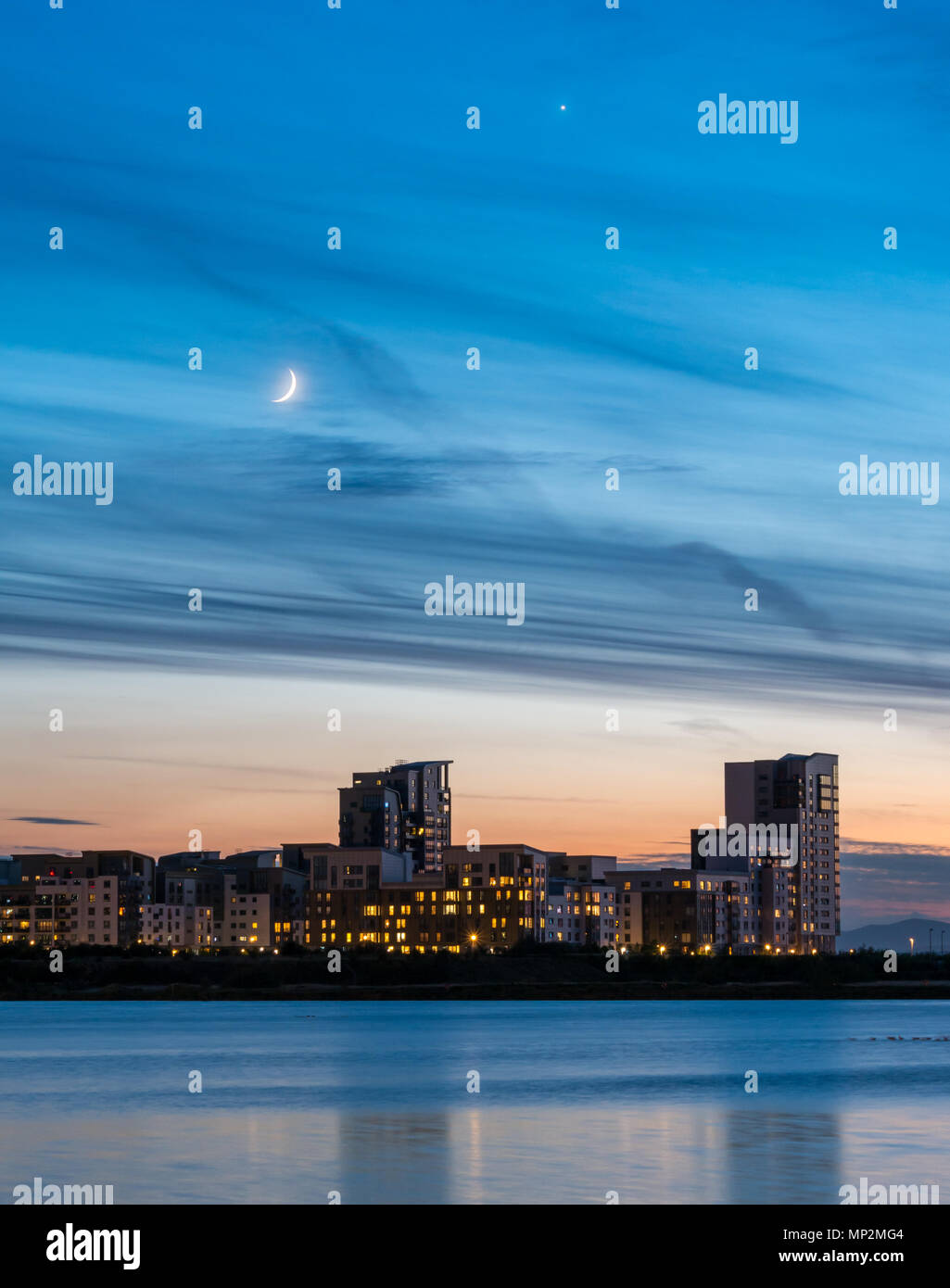Leith Edinburgh, Scotland, UK night sky with crescent super moon and Venus looking across Entrance Basin to high rise buildings of Platinum Point Stock Photo