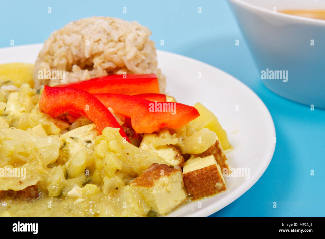 Cauliflower mixture with curry and rice on a blue background Stock