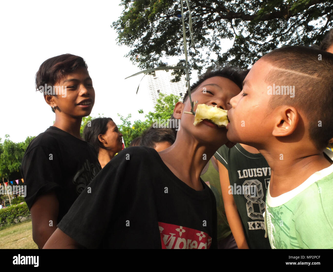 Manila, Philippines. 20th May, 2018. Two young boys trying to bite the apple in an apple eating