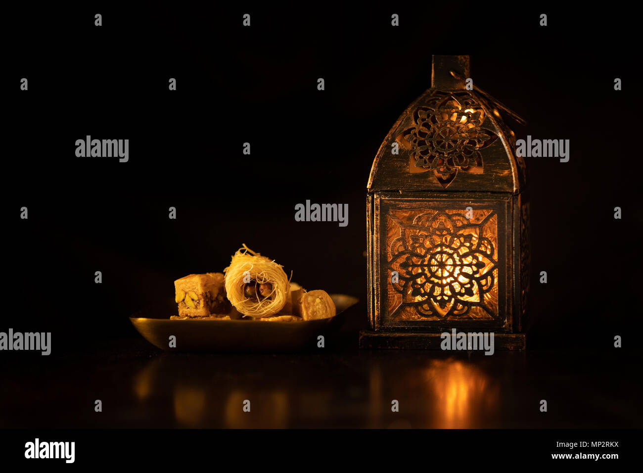 Traditional ornamental arabic lantern with a burning candle in dark