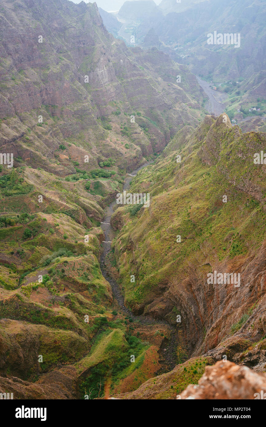 Breathtaking view of canyon with steep cliff and winding riverbed with lush green vegetation on Delgadinho mountain ridge. Santo Antao, Cape Verde Stock Photo