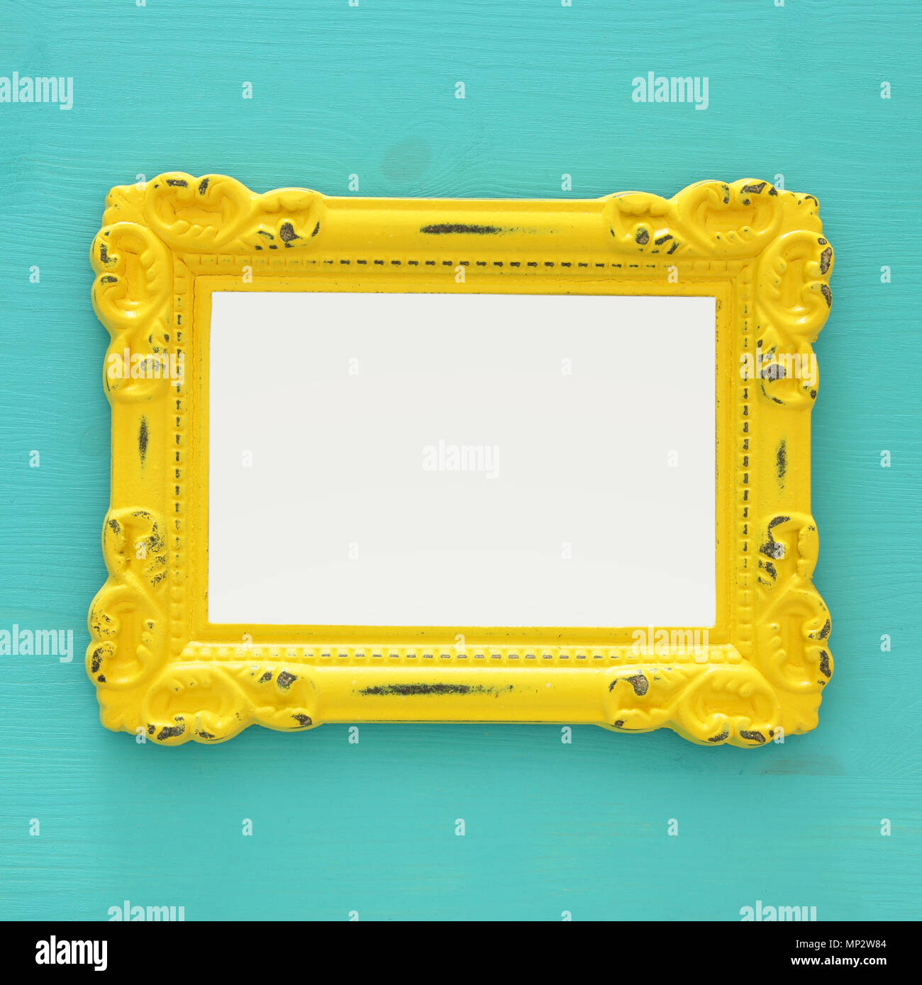 Vintage blank yellow photo frame over mint background. Ready for ...