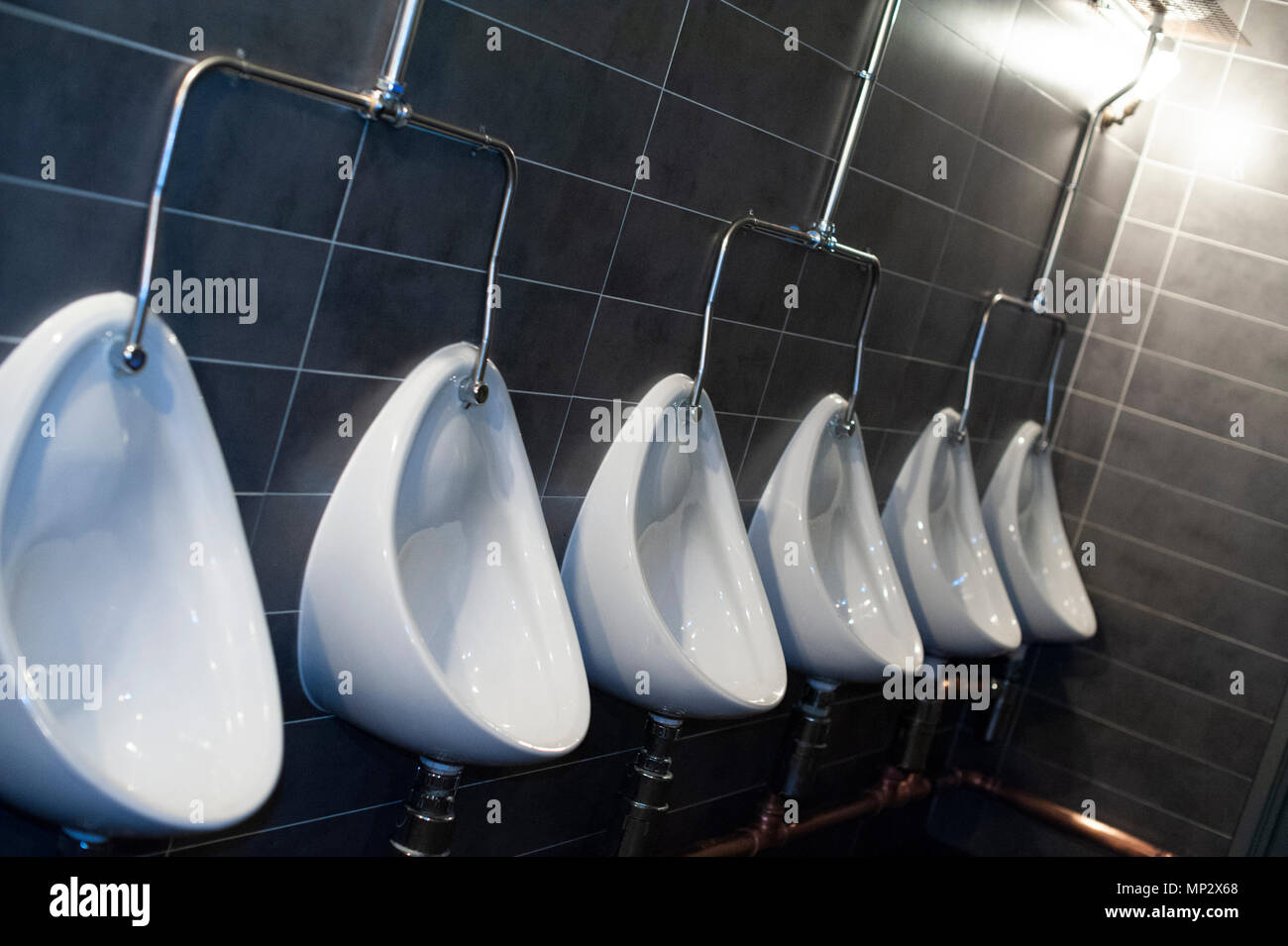 Row of mens urinals in a public toilet Stock Photo Alamy