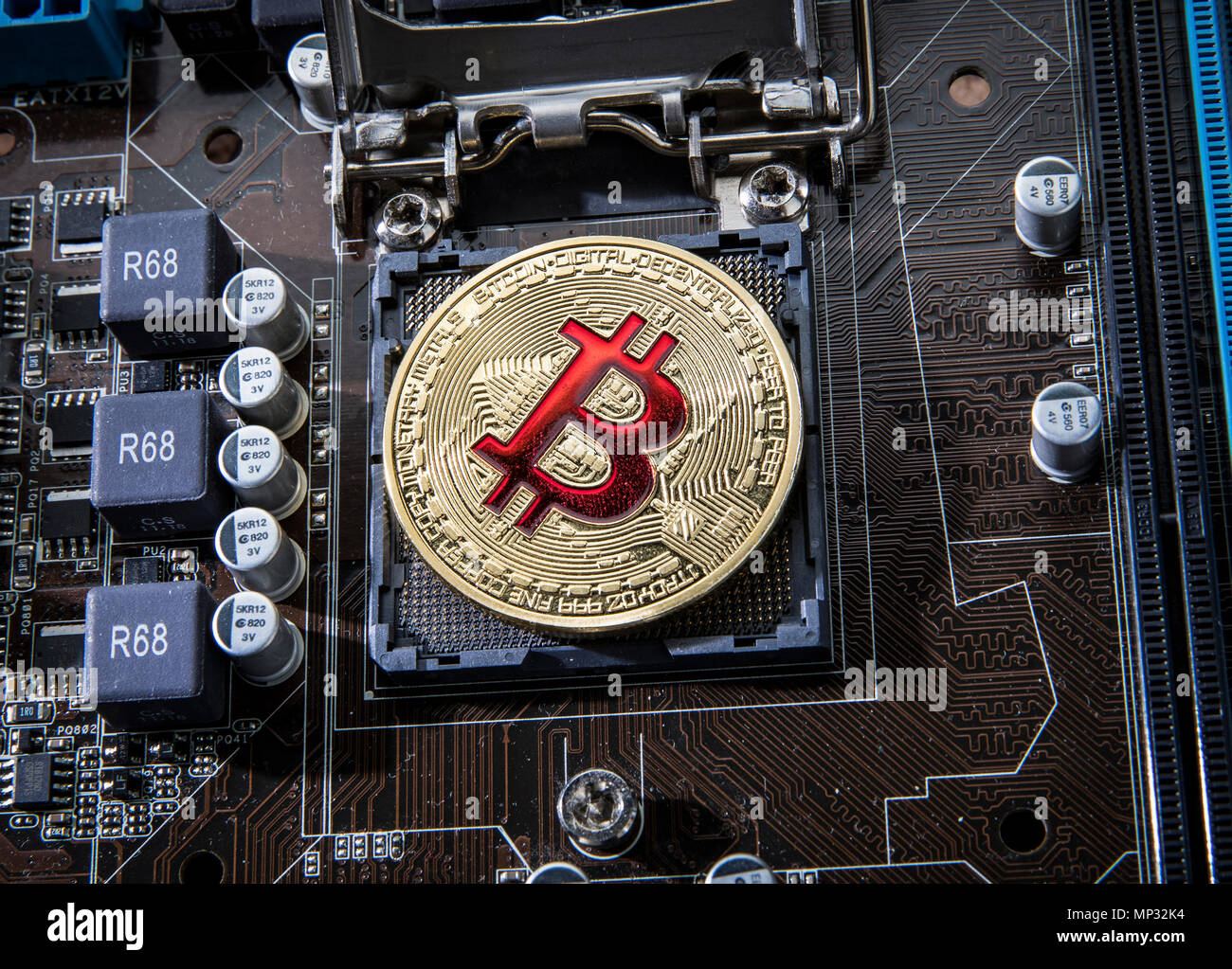Gold Bit Coin BTC coins on the motherboard. Bitcoin is a worldwide cryptocurrency and digital payment system called the first decentralized digital cu Stock Photo