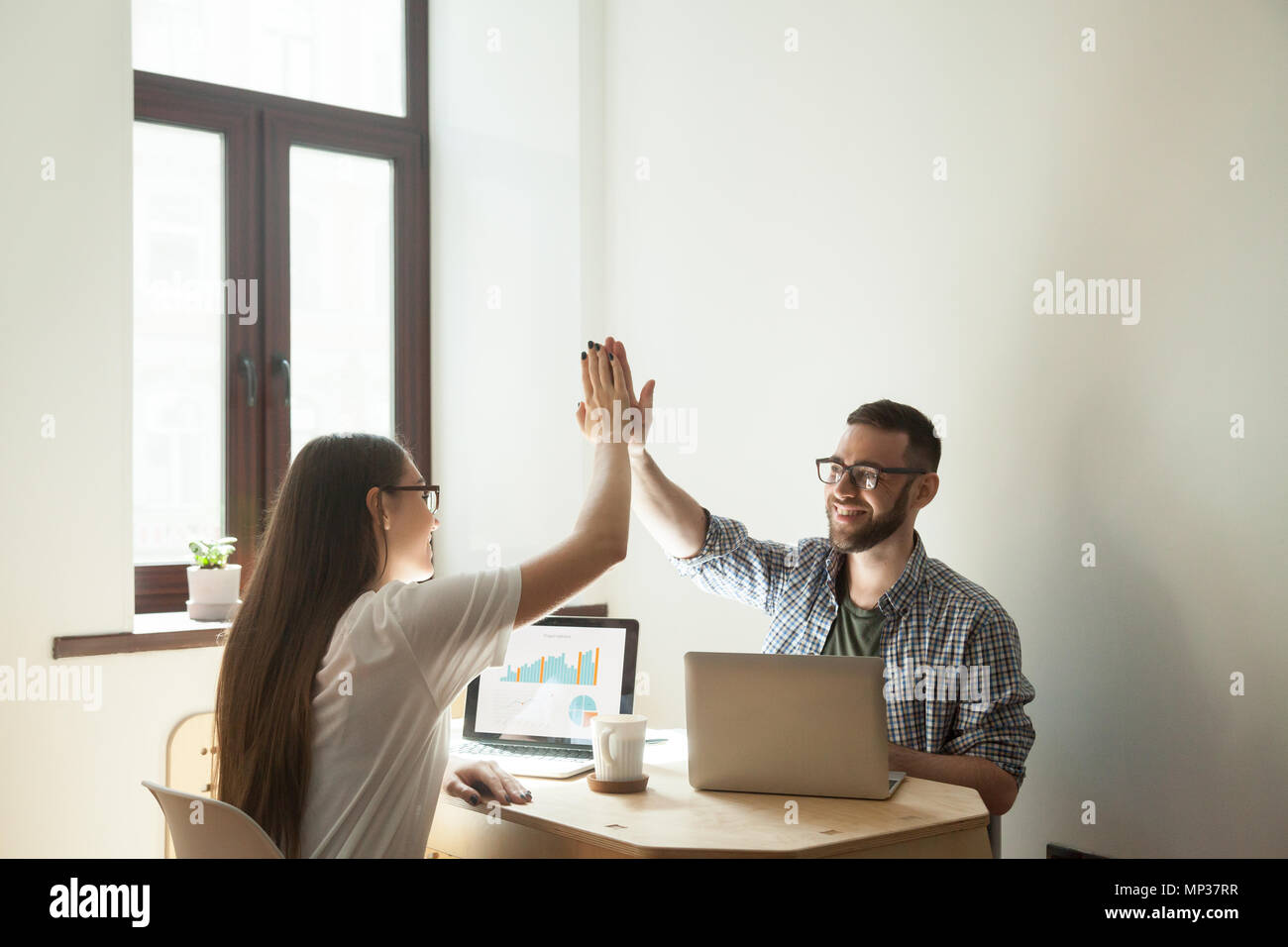 Freelance workers giving high five after successful project star Stock Photo