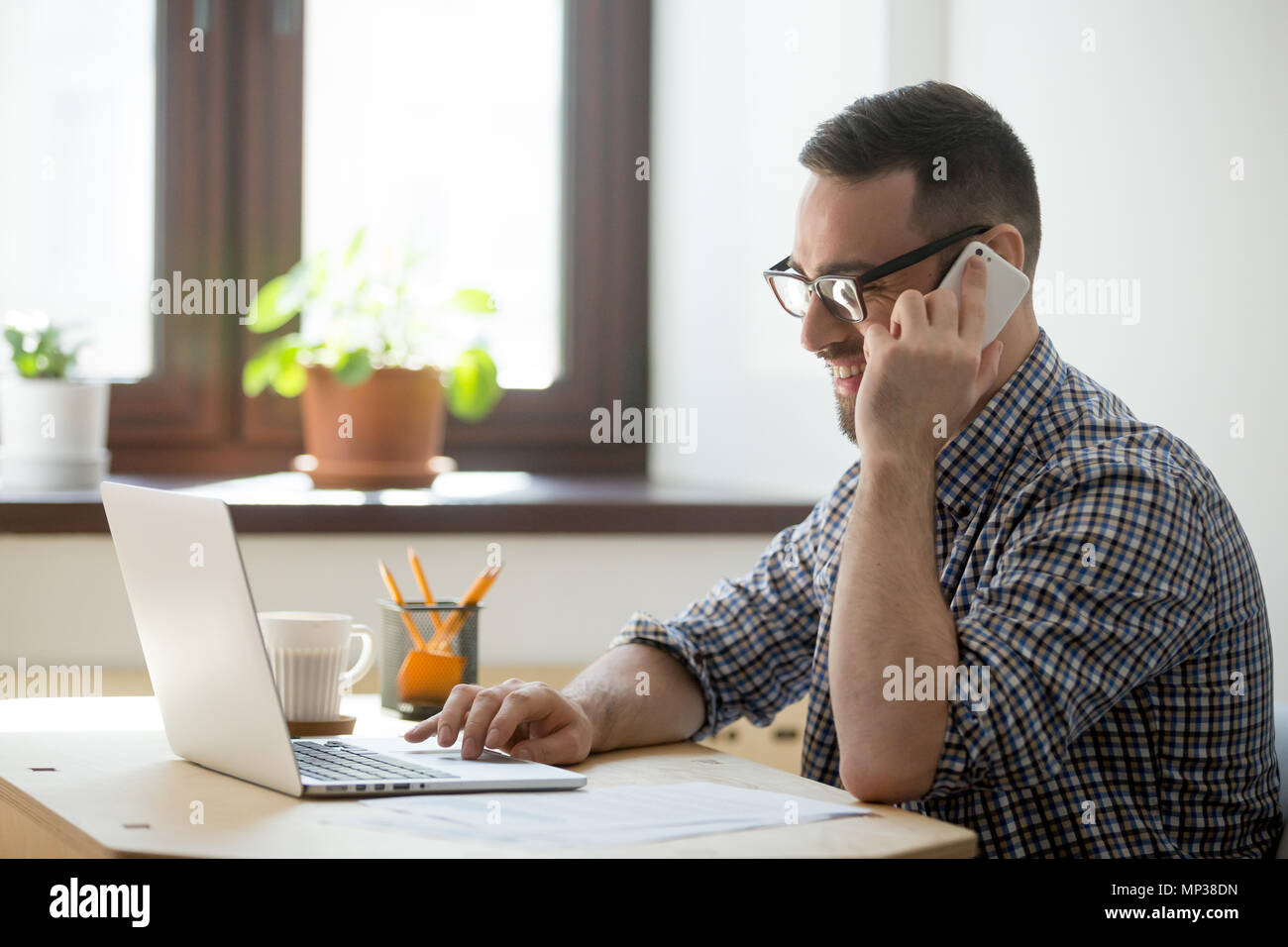 Smiling male consulting client online Stock Photo