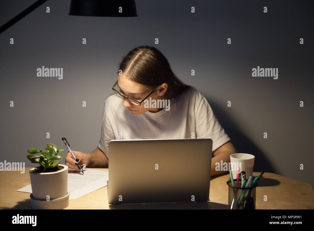 Focused student preparing for exam studying late hours Stock Photo