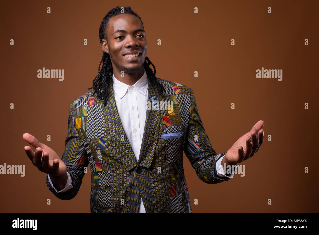 Young handsome African businessman against brown background Stock Photo