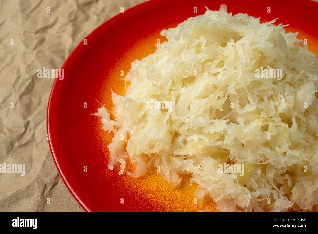 Fermented cabbage. Red plate of sauerkraut (pickled white cabbage Stock
