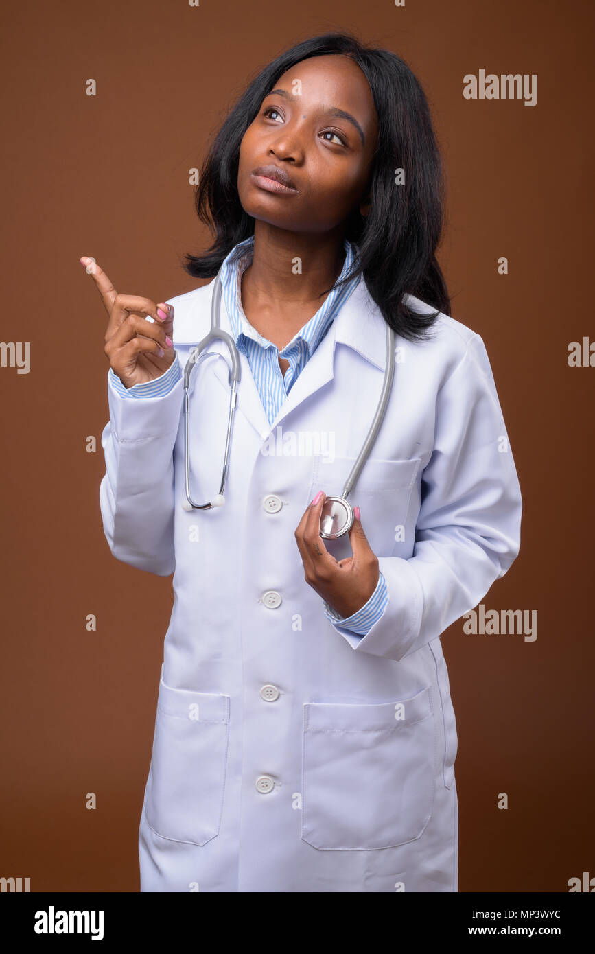 Young beautiful African Zulu woman doctor against brown backgrou Stock ...