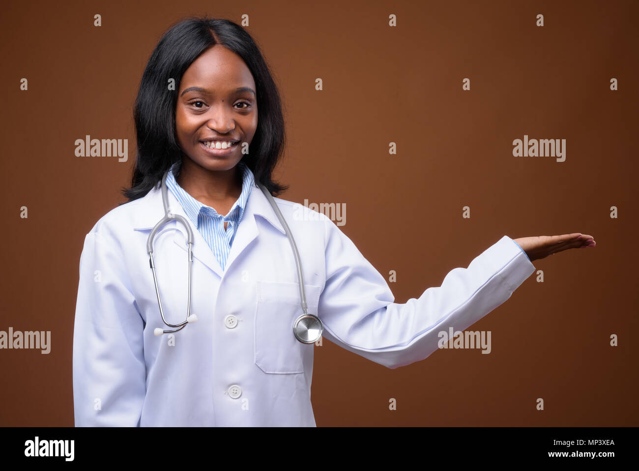 Young beautiful African Zulu woman doctor against brown backgrou Stock ...
