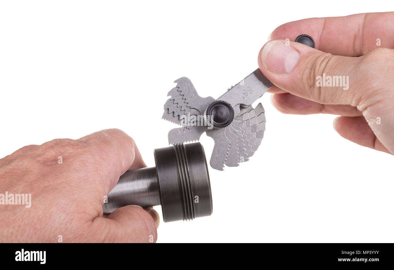 Thread pitch gauge measurement close-up. Detail of machinist's hands, set of threaded gauges and workpiece. Steel jig, measuring hand tool. Isolated. Stock Photo