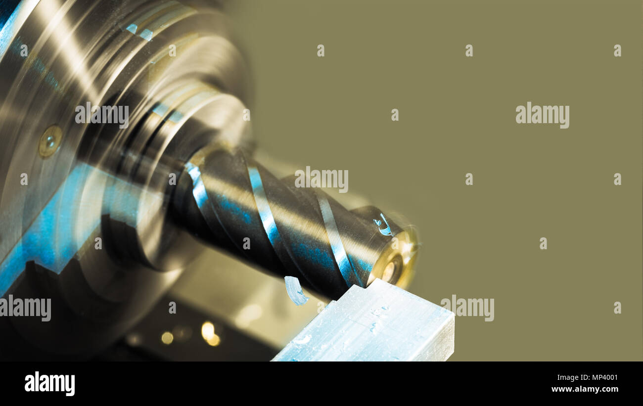 Cutting an aluminum workpiece. Beautiful industrial background. Close-up of endmill clamped in chuck of milling machine. Processing a duralumin part. Stock Photo