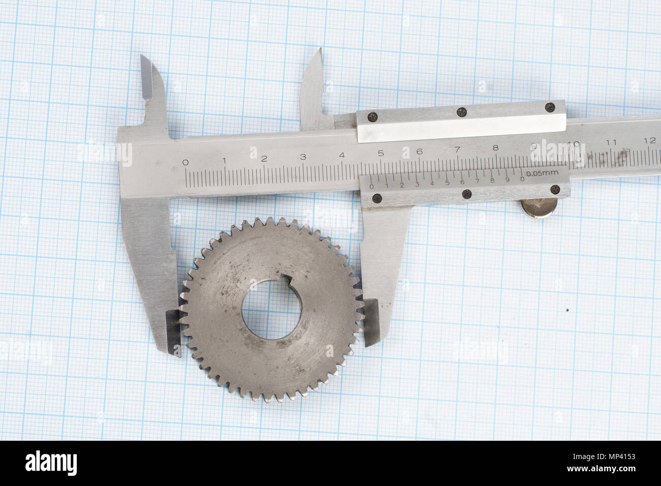gear and caliper on graph paper background Stock Photo Alamy