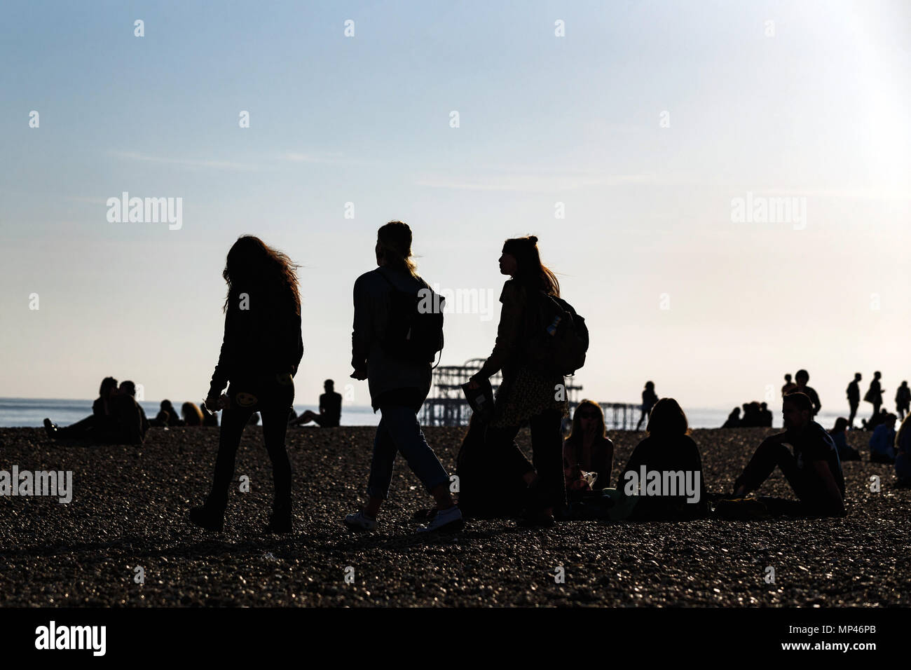 Silhouette figures on Brighton seafront on a warm evening. Brighton, East Sussex, UK. Stock Photo