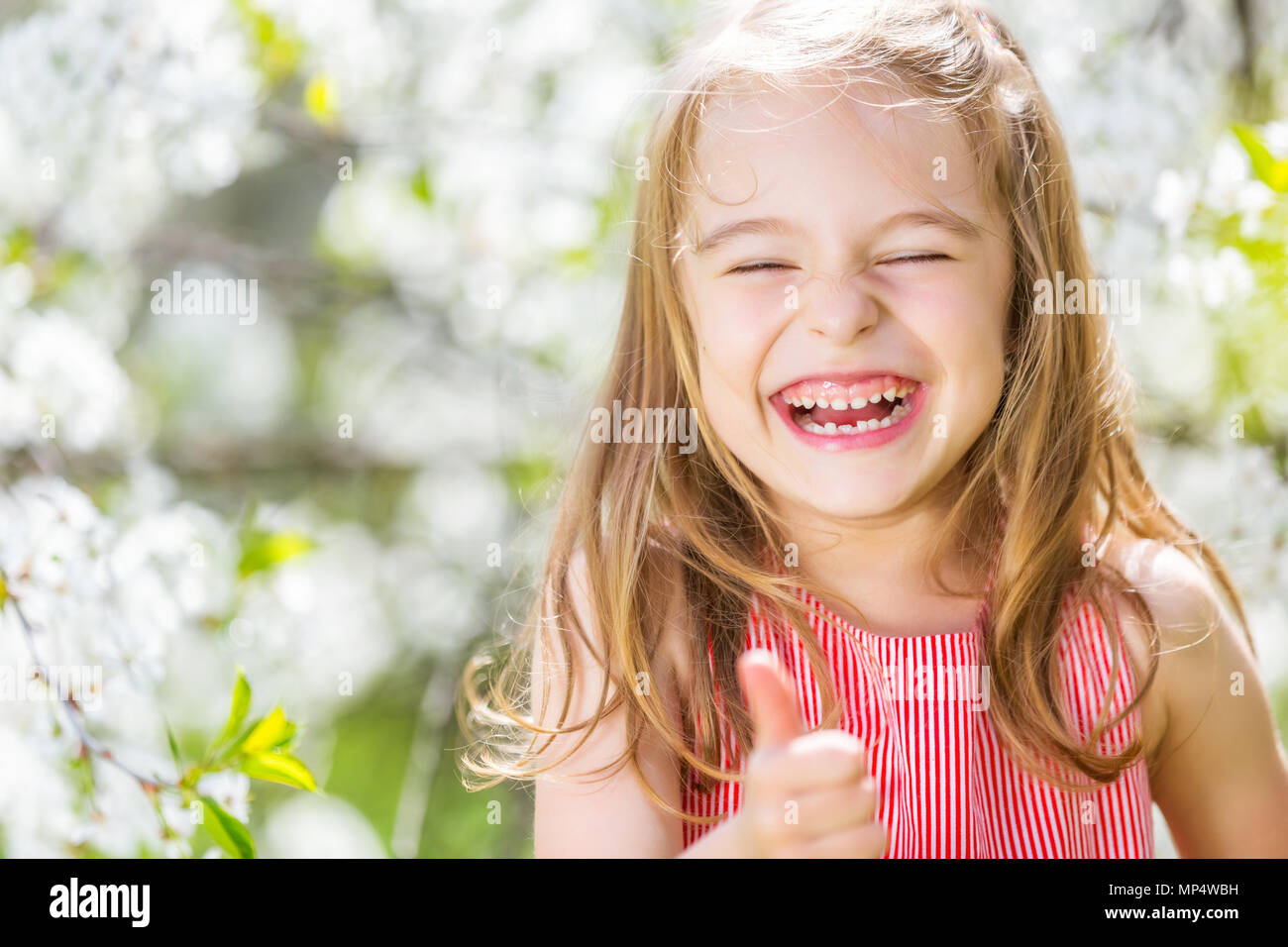 Happy little girl in cherry blossom garden Stock Photo Alamy