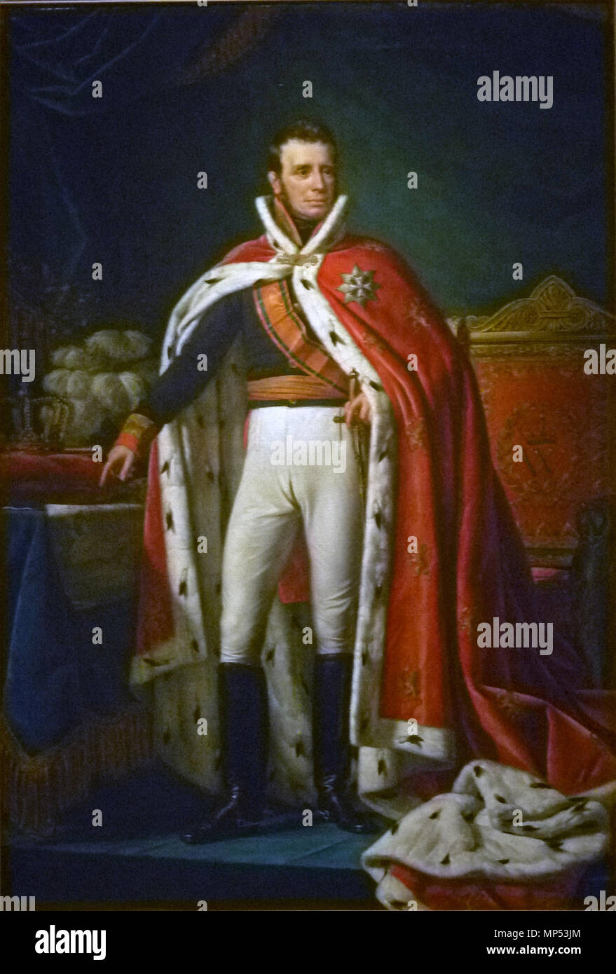Portrait of William I, King of the Netherlands. Portrait of William I (1772–1743) as King of the United Kingdom of the Netherlands. Standing, at full-length, in the gala uniform of a general. Over his right shoulder the sash of the Military William Order. Over his uniform wearing a red robe lined with ermine. To the right the royal throne, to the left a table with on it the map of parts of Java (Bantam, Jacatra and Cheribon) in modern-day Indonesia, and also a pillow with crown and sceptre and a hat with ostriche feathers. 1819.   742 Joseph Paelinck - Willem I 001 Stock Photo