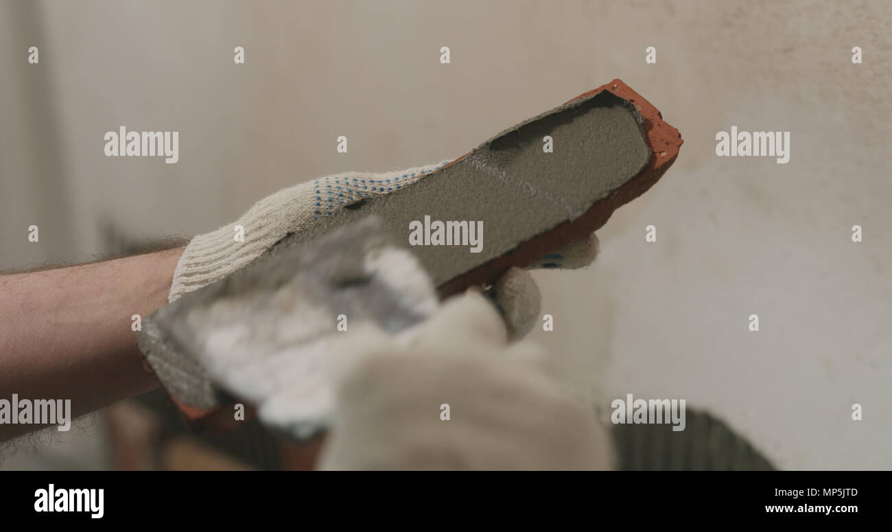 closeup worker applying concrete glue to brick cuts tile Stock Photo Alamy