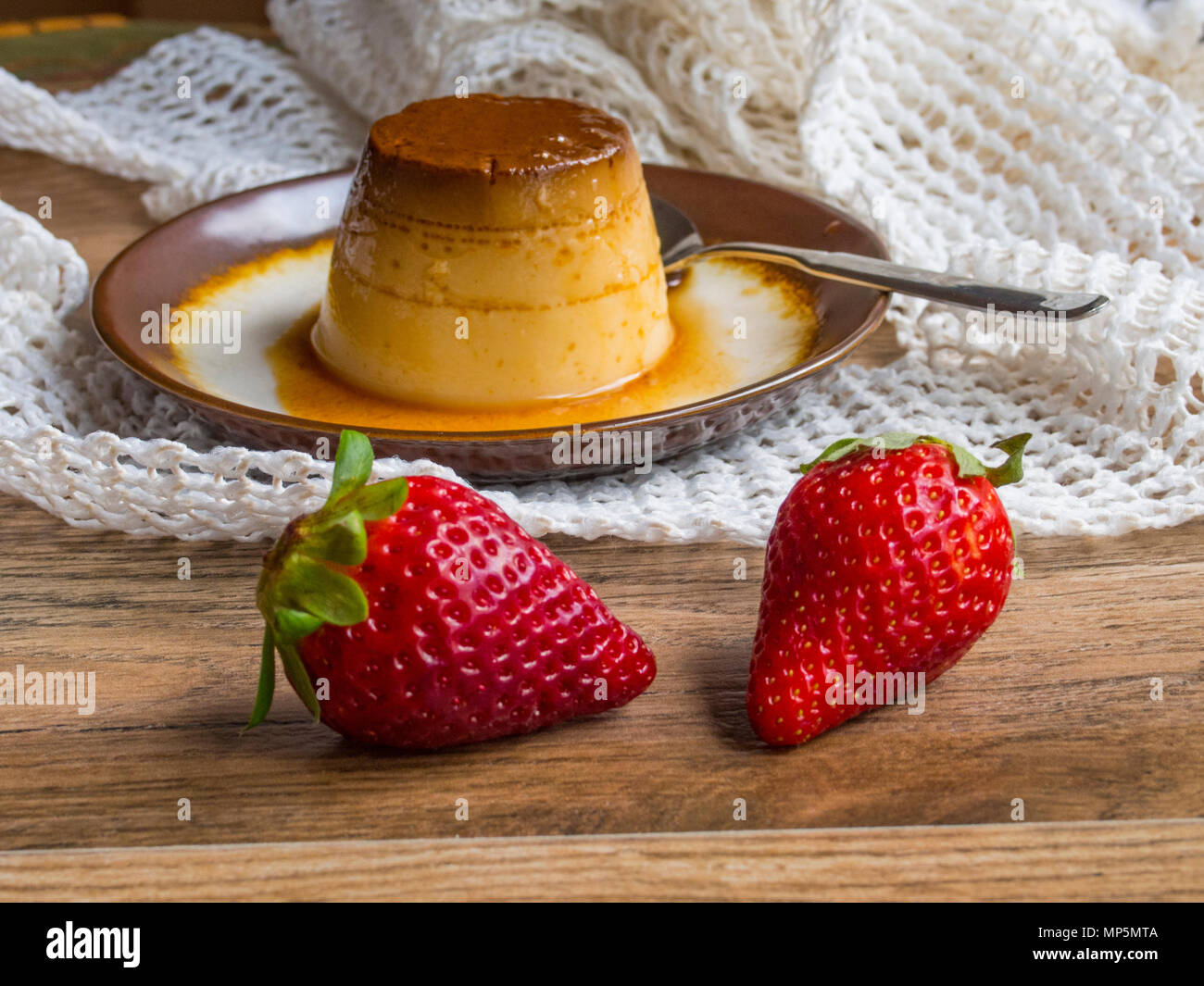 Flan in a plate on wood background Stock Photo