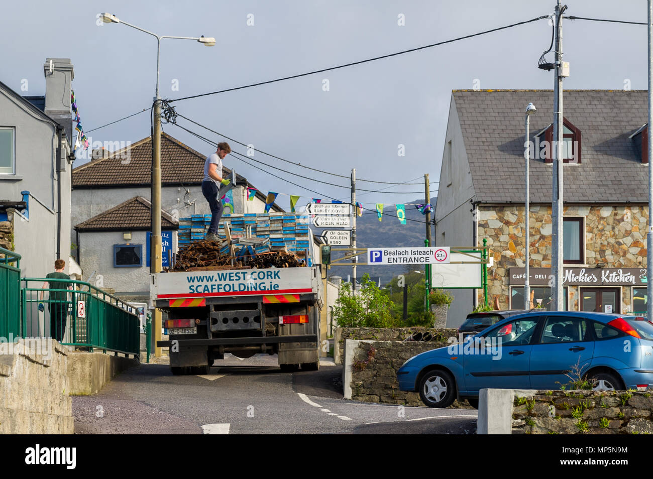 Scaffold workers taking down scaffolding and scaffold planks with swift nesting boxes on wall in Schull, County Cork, Ireland with copy space. Stock Photo