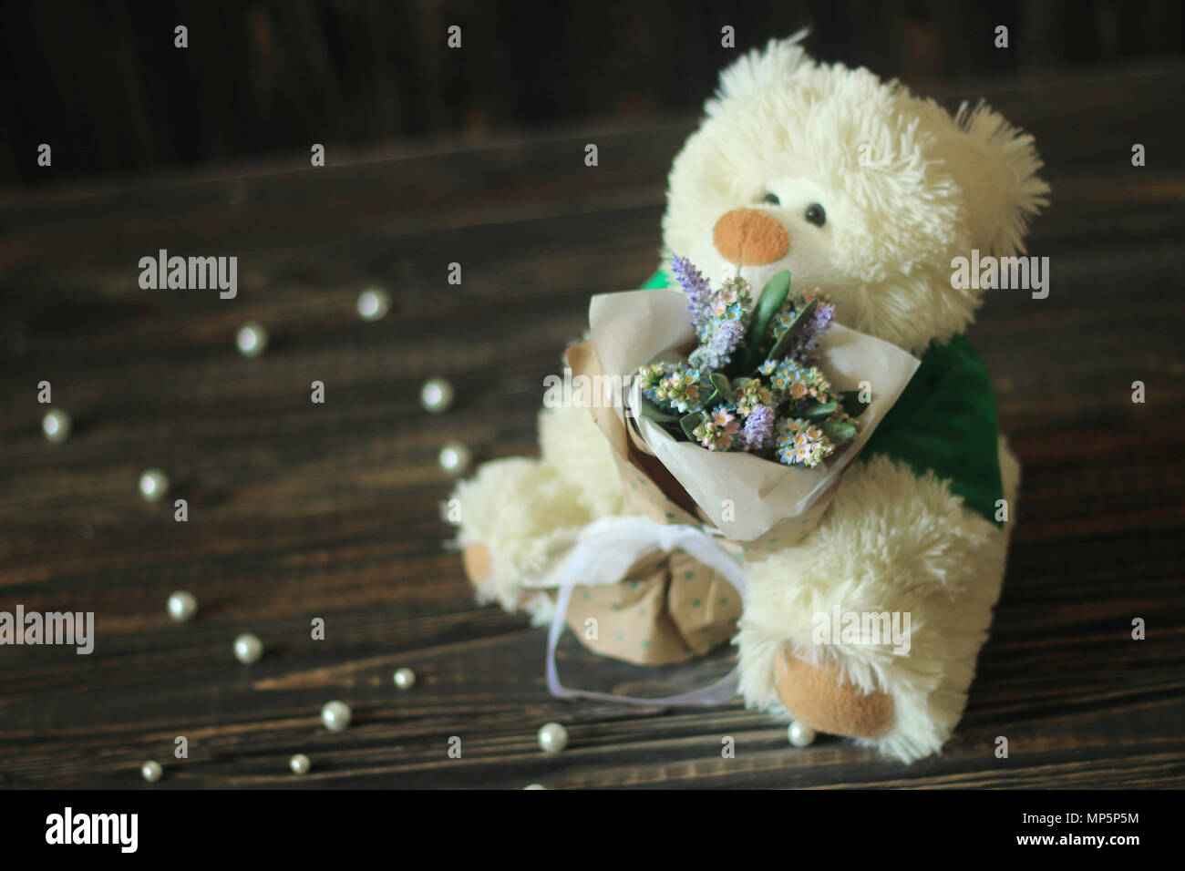 Flowers and a teddy bear Stock Photo - Alamy