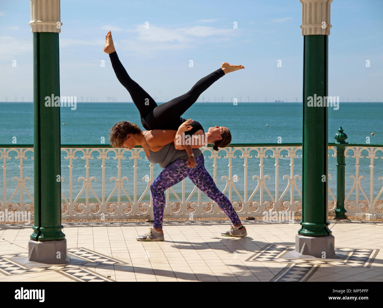 On the sunny Brighton seafront fit young people practice acroyoga Stock Photo