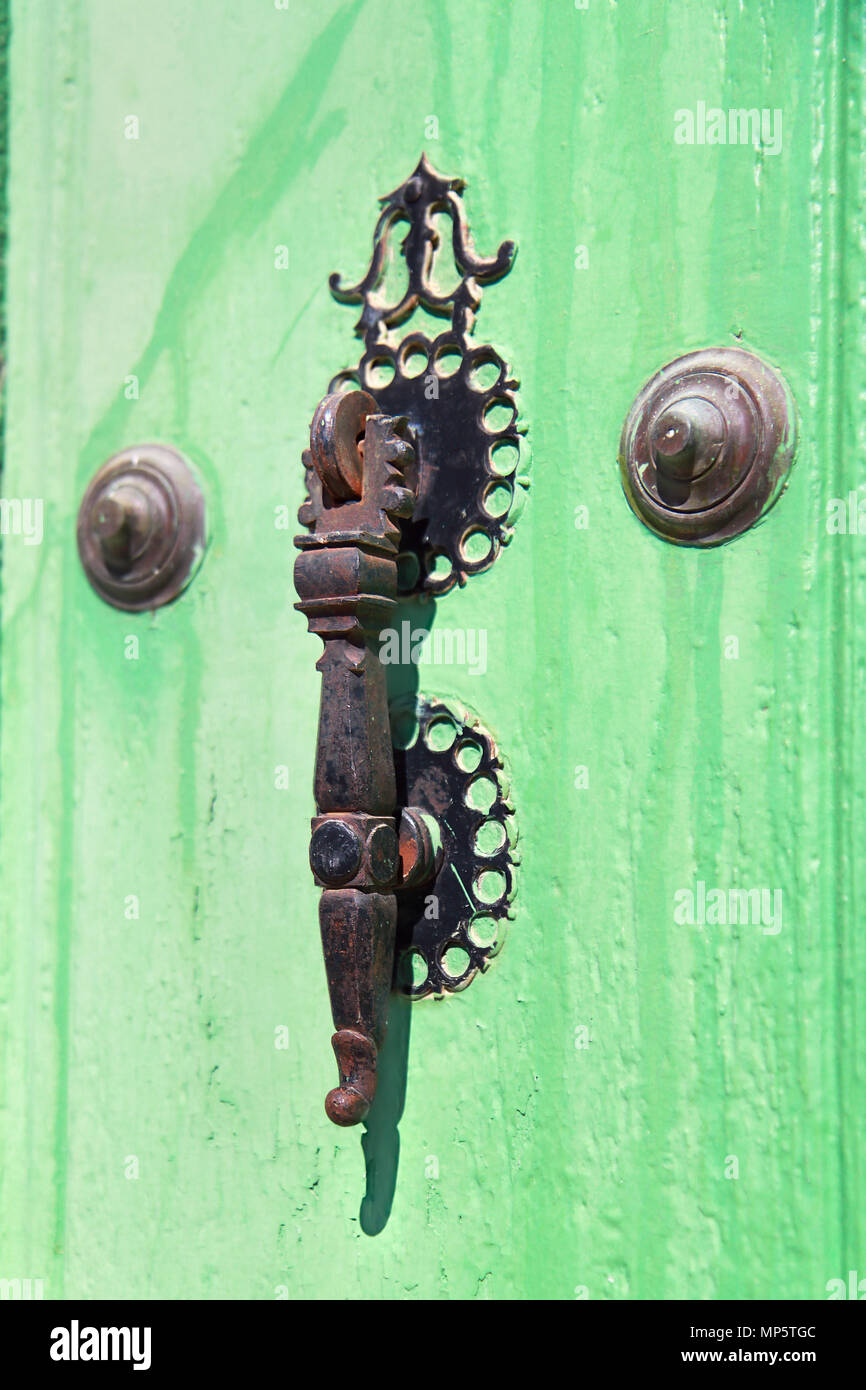 Old metal door handle colonial style on green door, Trinidad , Cuba