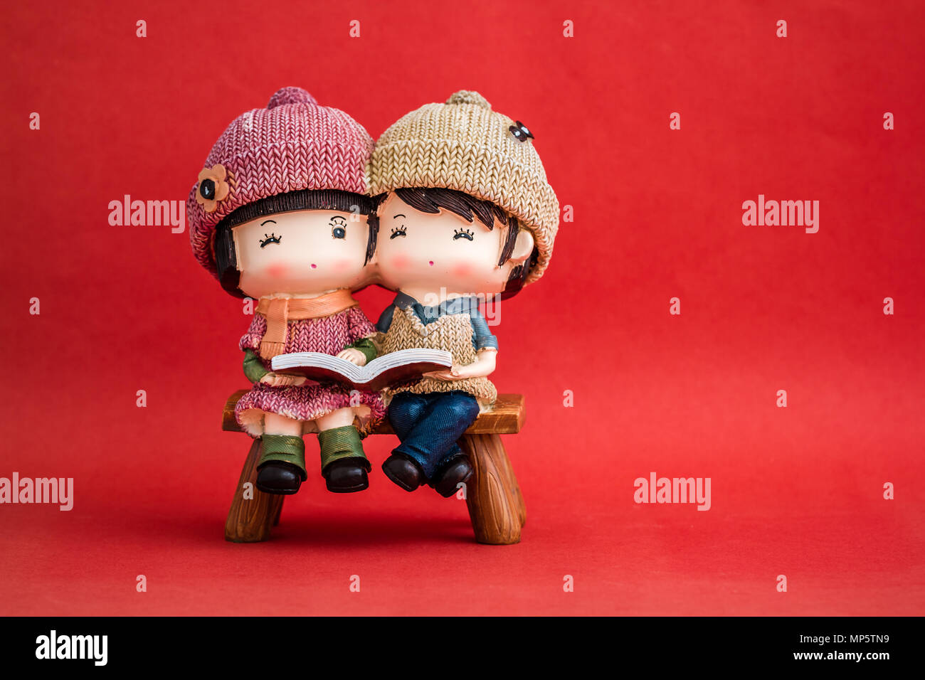 Cute couple figurines on red background Stock Photo - Alamy